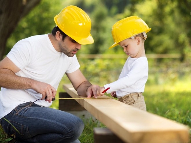 Отец с сыном измеряют деревянную доску